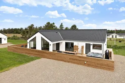 a house with a large wooden deck in a yard at 667-Thisted-Smedevej-3-C in Thisted