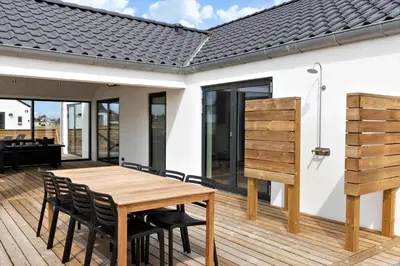 a deck with a wooden table and chairs on a house at 667-Thisted-Smedevej-3-C in Thisted