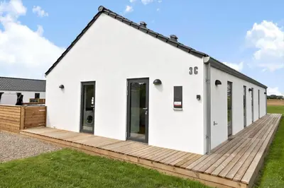 a white house with a wooden deck at 667-Thisted-Smedevej-3-C in Thisted