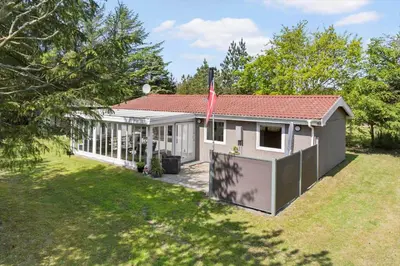 a small white house with a flag in a yard at 317-Thisted-Molgaardsvej-65 in Thisted