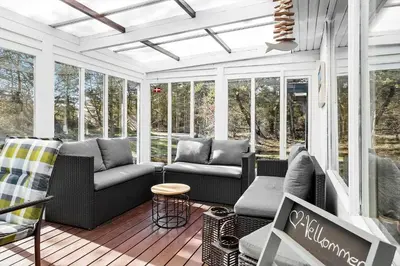 a screened in porch with couches and chairs at 317-Thisted-Molgaardsvej-65 in Thisted