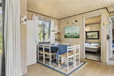 a dining room with a table and chairs and a bedroom at 982-Thisted-Clemmessti-16 in Torsted