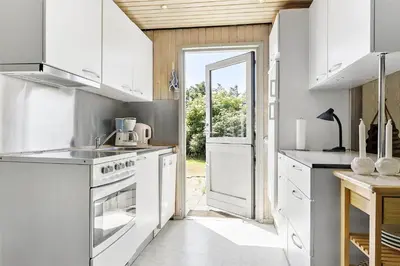 a kitchen with white appliances and an open door at 982-Thisted-Clemmessti-16 in Torsted