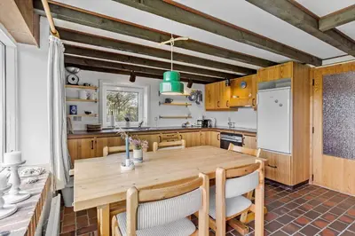 a kitchen with a wooden table and chairs at 641-Snedsted-Istrupvej-21-C in Snedsted