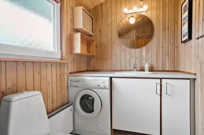 a bathroom with a washing machine and a sink at 940-Thisted-Spanggardsvej-45 in Torsted