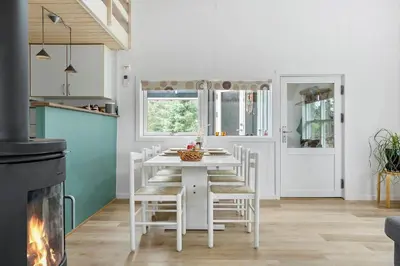 a kitchen with a white table and chairs and a fireplace at 669-Thisted-Kristinesvej-68 in Thisted