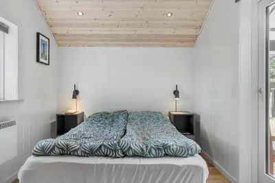 a bed in a white room with two lamps on tables at 669-Thisted-Kristinesvej-68 in Thisted