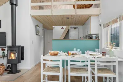 a white dining room with a table and a fireplace at 669-Thisted-Kristinesvej-68 in Thisted
