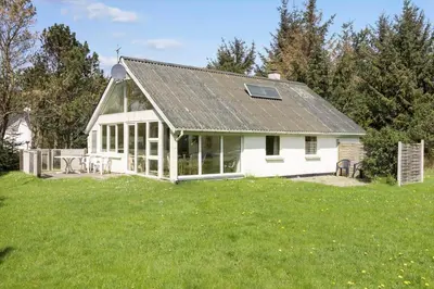 a white house with a roof on a green field at 749-Thisted-Nordsovej-214 in Thisted