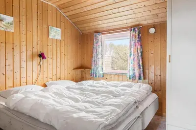 a large white bed in a wooden room with a window at 749-Thisted-Nordsovej-214 in Thisted