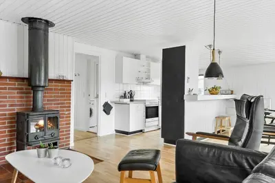 a living room with a couch and a table and a fireplace at 855-Thisted-Flyndervej-5 in Thisted