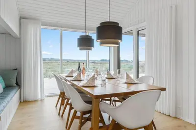 a dining room with a table and white chairs at 1056-Thisted-Johns-Vej-16 in Torsted