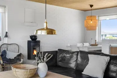 a living room with a black leather couch and a fireplace at 234-Thisted-Kuttervej-9 in Thisted