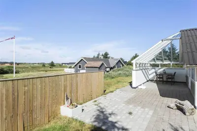 a backyard with a wooden fence and a patio at 807-Thisted-Grarisvej-13 in Thisted
