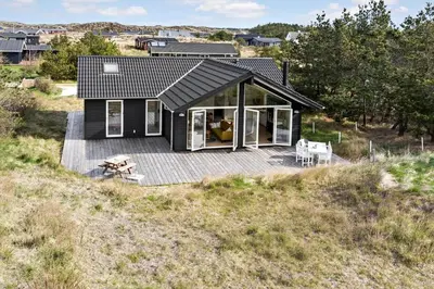 a small black house with a deck on a hill at 192-Snedsted-Sarasvej-12 in Snedsted