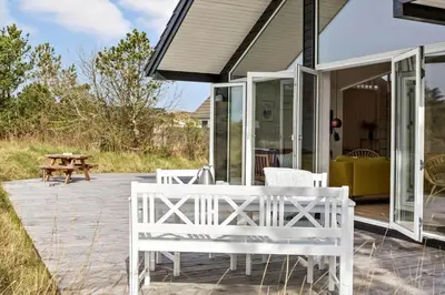 a porch with white chairs and a picnic table at 192-Snedsted-Sarasvej-12 in Snedsted