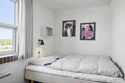 a bed in a bedroom with two pictures on the wall at 219-Thisted-Fiskervej-16 in Thisted