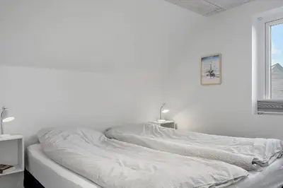 a white bed in a white room with a window at 1302-Thisted-Havstokken-30-1 in Thisted