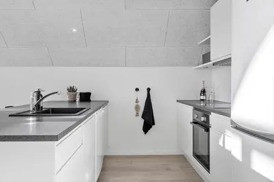 a white kitchen with a sink and a stove at 1302-Thisted-Havstokken-30-1 in Thisted