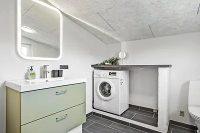 a bathroom with a washing machine and a sink at 511-Thisted-Blabaervej-16 in Thisted