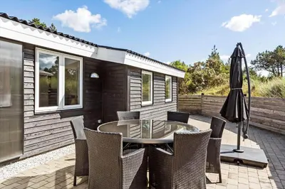 a patio with a table and chairs and an umbrella at 511-Thisted-Blabaervej-16 in Thisted