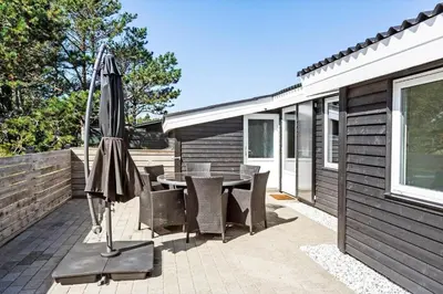 a patio with a table and chairs and an umbrella at 511-Thisted-Blabaervej-16 in Thisted