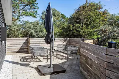 a patio with an umbrella and chairs and a table at 511-Thisted-Blabaervej-16 in Thisted
