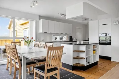 a kitchen with a table and chairs and a kitchen with white cabinets at 942-Thisted-Orhagevej-183 in Torsted