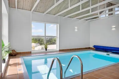 a swimming pool in a room with a large window at 942-Thisted-Orhagevej-183 in Torsted