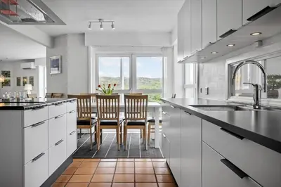a kitchen with white cabinets and a table with chairs at 942-Thisted-Orhagevej-183 in Torsted
