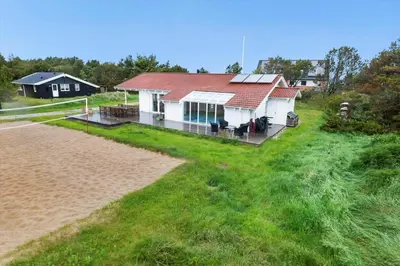 a white house with a red roof on a beach at 931-Thisted-Pinbak-24 in Torsted