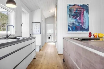 a large kitchen with white cabinets and a painting on the wall at 931-Thisted-Pinbak-24 in Torsted