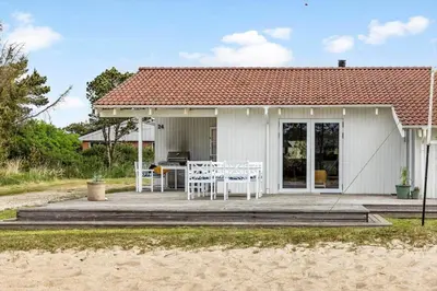 a house with a table and chairs on a deck at 931-Thisted-Pinbak-24 in Torsted