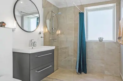 a bathroom with a sink and a shower with a mirror at 167-Thisted-Vesterhavsgade-158 in Thisted