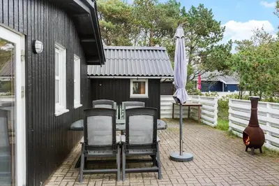 a patio with a table and chairs and an umbrella at 645-Thisted-Blabaervej-4 in Thisted