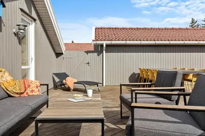 a patio with a couch and chairs on a deck at 504-Thisted-Nordsovej-206-C in Thisted