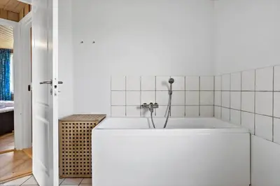 a white bathroom with a tub in a room at 916-Thisted-Spanggardsvej-59 in Torsted
