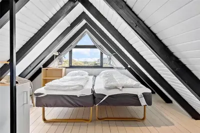 two beds in a attic room with a window at 1007-Thisted-Mombak-7 in Torsted