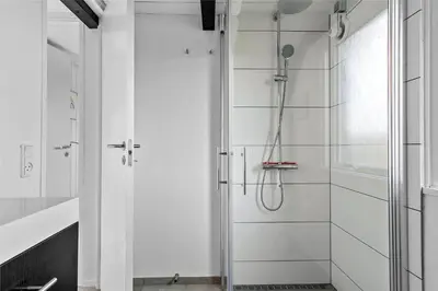 a white bathroom with a shower and a glass door at 1007-Thisted-Mombak-7 in Torsted