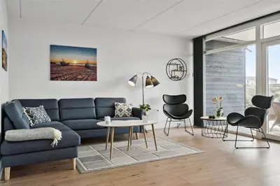 a living room with a blue couch and a table and chairs at 774-Thisted-Havstokken-26-A in Thisted