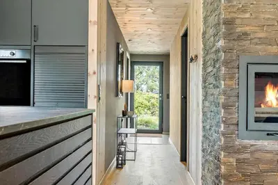 a kitchen with a fireplace and a stone wall at 157-Thisted-Isfuglevej-17 in Thisted