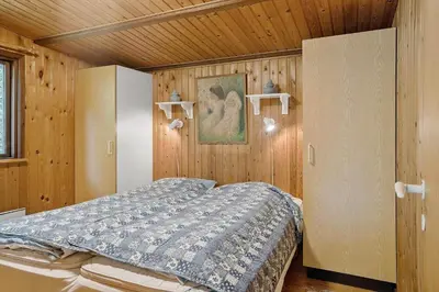 a bedroom with a bed in a room with wooden walls at 242-Thisted-Muslingevej-4 in Thisted
