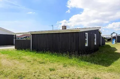 a black building sitting in a grass field at 870-Thisted-Nordsovej-34 in Thisted