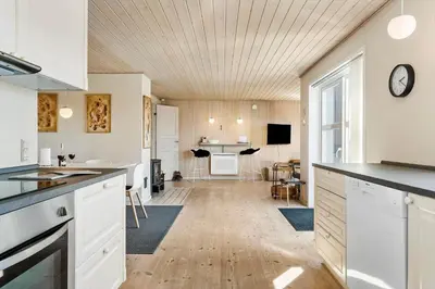 a kitchen with white cabinets and a table in it at 870-Thisted-Nordsovej-34 in Thisted