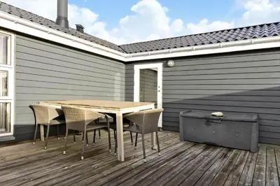 a wooden table and chairs on a deck at 1059-Klitmoller-Mollebakken-56 in Klitmøller