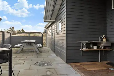 a patio with a table and a picnic table at 1059-Klitmoller-Mollebakken-56 in Klitmøller