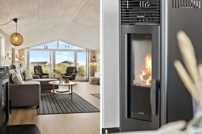 a living room with a fireplace and a living room with a couch at 1059-Klitmoller-Mollebakken-56 in Klitmøller