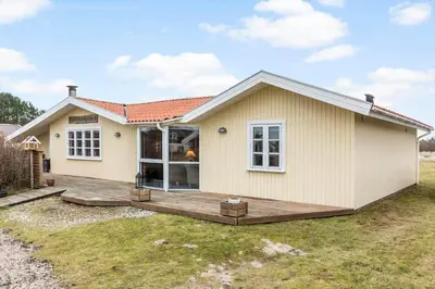 a small white house with a wooden deck at 388-Thisted-Hummervej-8 in Thisted