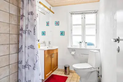 a bathroom with a toilet and a sink and a window at 388-Thisted-Hummervej-8 in Thisted