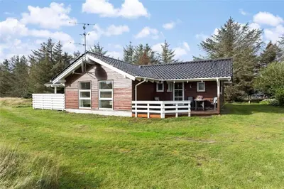 a small house in a field with a grass yard at 858-Thisted-Delfinvej-24 in Thisted